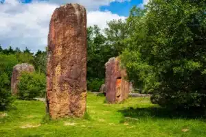 Grands monolithes rouges dans une clairière verdoyante à Monteneuf
